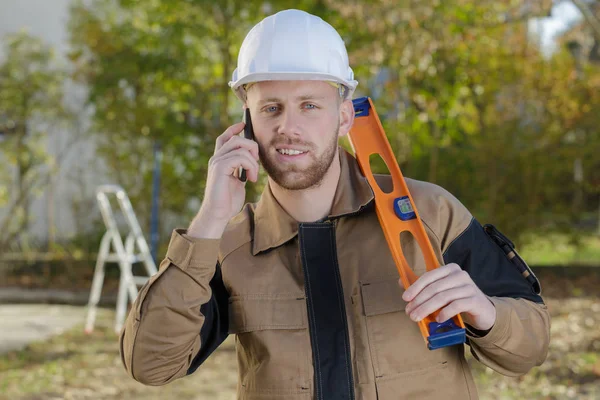 Constructor en el sitio usando el teléfono móvil — Foto de Stock