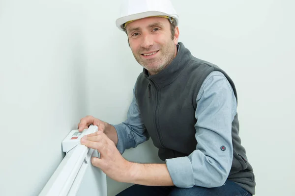 Electrician inspecting the radiator — Stock Photo, Image