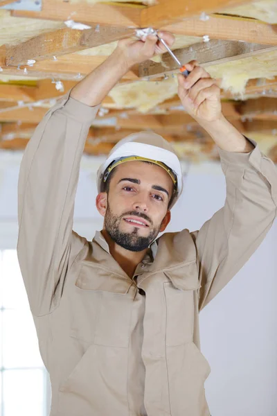 Tavanı tamir eden bir inşaat işçisi — Stok fotoğraf