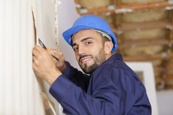 A tradesman is stripping wallpaper — Stock Photo, Image