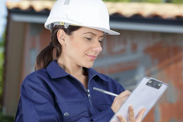 Construção trabalhador feminino segurando prancheta — Fotografia de Stock