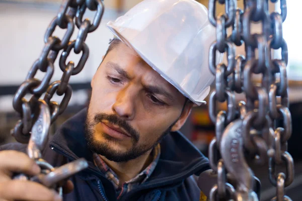 Uilder debout près de la chaîne avec crochet de grue — Photo