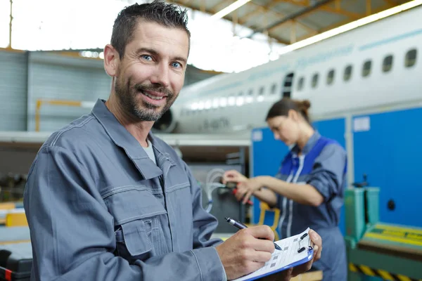 Felice meccanico uomo con appunti in officina — Foto Stock