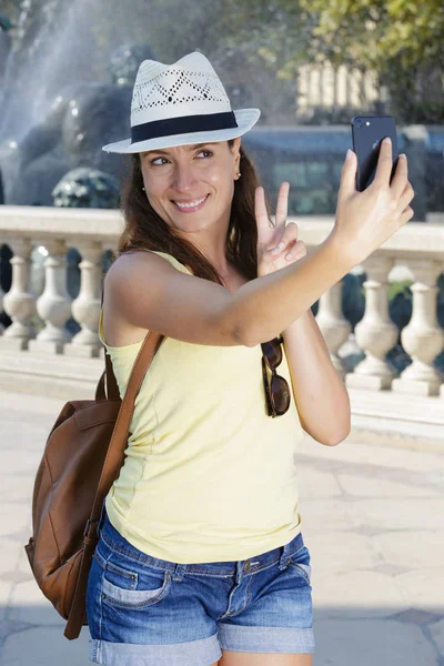 Kobieta biorąc selfie przez architektoniczny punkt orientacyjny — Zdjęcie stockowe
