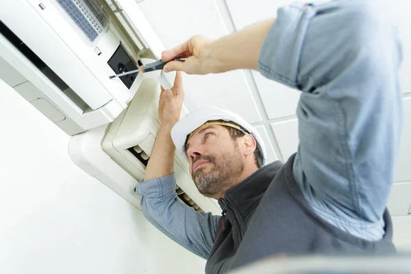 Young man cleaning air conditioning system — Stock Photo, Image
