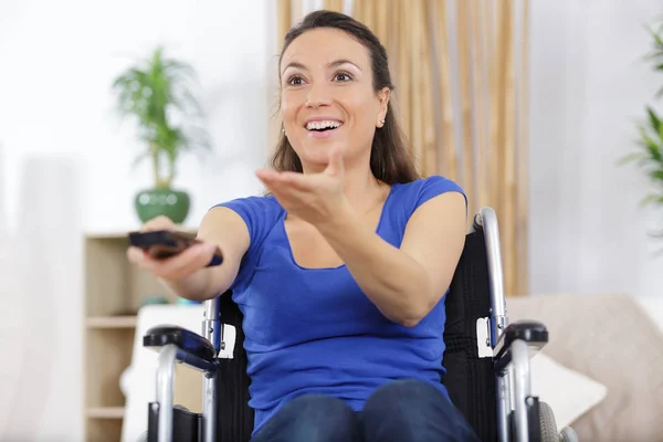 Mulher deficiente alegre assistindo televisão na sala de estar — Fotografia de Stock