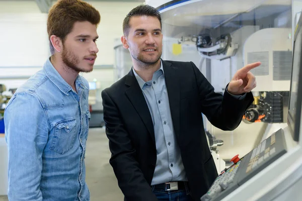 Engineer showing machinery controls to students — Stock Photo, Image