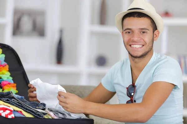 Mann packt seinen grauen Koffer im Wohnzimmer — Stockfoto