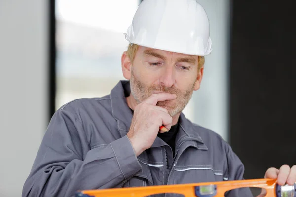 Constructor utilizando un nivel cerca de la pared —  Fotos de Stock