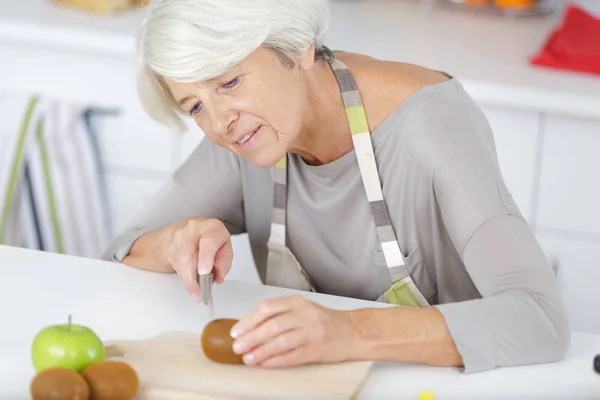 Ηλικιωμένη γυναίκα ετοιμάζει υγιεινό δείπνο — Φωτογραφία Αρχείου