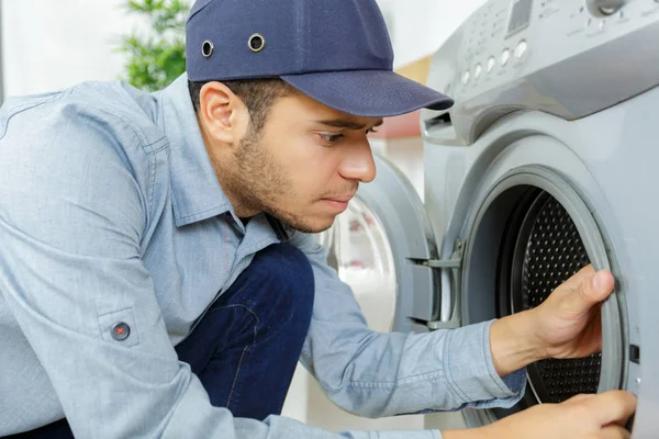 Plumber with clipboard near washing machine — Stock Photo, Image