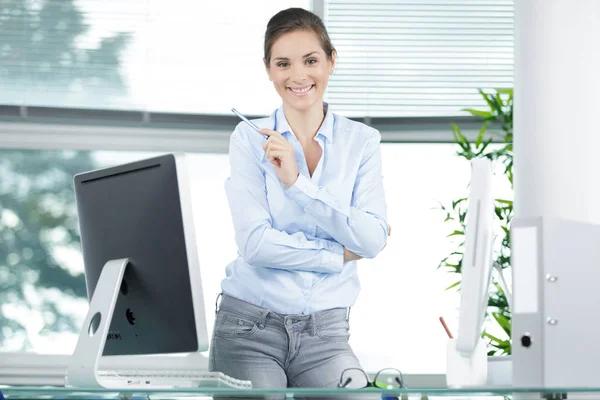 Happy young businesswoman laughing in the office — Stok fotoğraf