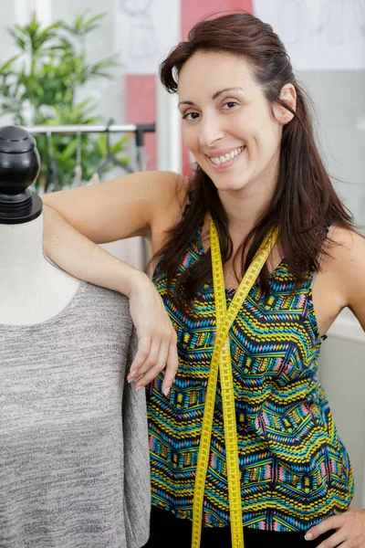 Portrait of dressmaker leaning on mannequin — Stockfoto