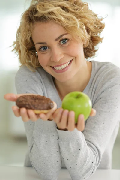 Kvinna Väljer Mellan Äpple Och Munk — Stockfoto