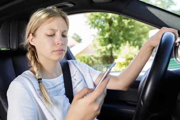 Γυναίκα Οδηγός Που Διαβάζετε Ένα Μήνυμα Κειμένου Ένα Κινητό — Φωτογραφία Αρχείου