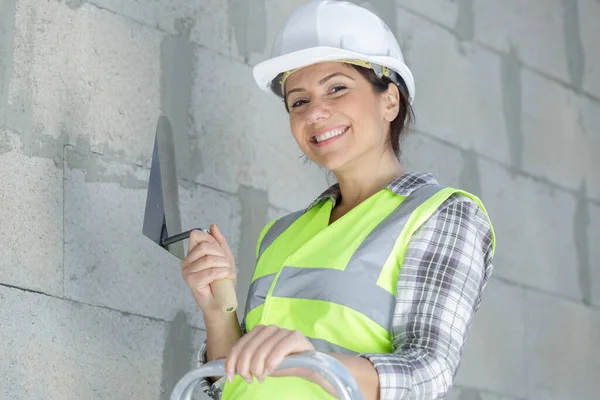 Glückliche Arbeiterin Legt Gips Auf Einen Spachtel — Stockfoto