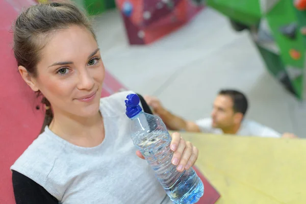 Młoda Kobieta Pijąca Wodę Przed Ścianą Wspinaczkową — Zdjęcie stockowe