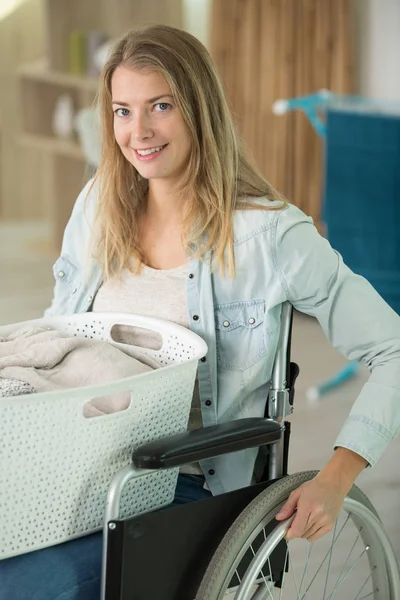 Kucağında Çamaşır Sepetiyle Tekerlekli Sandalyedeki Kız — Stok fotoğraf