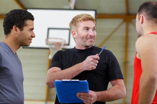 Basketballtrainer Gespräch Mit Zwei Teammitgliedern — Stockfoto