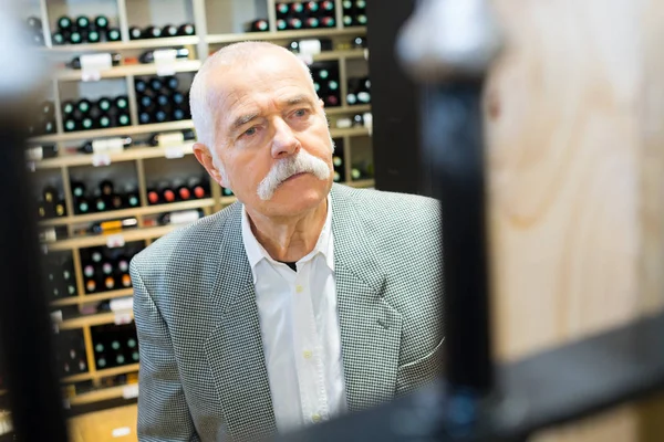 Lachende Senior Man Kiezen Van Wijn Supermarkt — Stockfoto