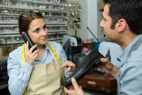 Zapatera Femenina Con Smartphone Discutiendo Orden Del Cliente Por Lugar —  Fotos de Stock