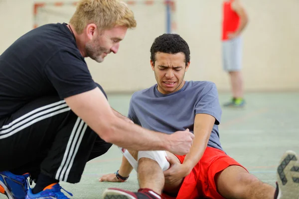 Treinador Bandagem Joelho Jovem Desportista Ferido — Fotografia de Stock