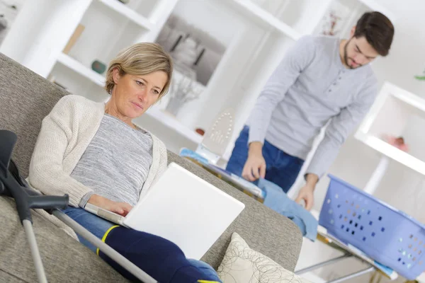 Mujer Sofá Con Lesión Pierna Hombre Planchado — Foto de Stock