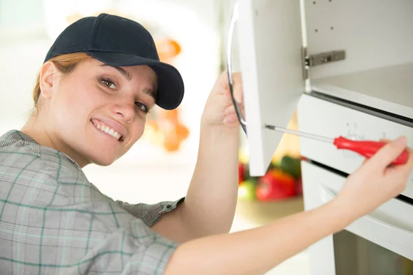 Junge Frau Montiert Mit Schraubenzieher Küchenmöbel — Stockfoto