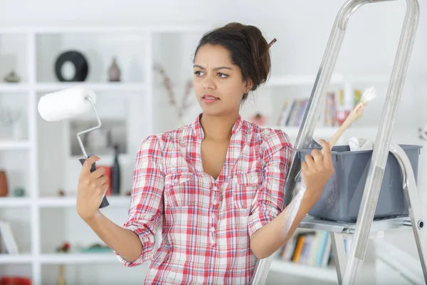 Young Lady Comparing Paintbrush Roller — Stock Photo, Image