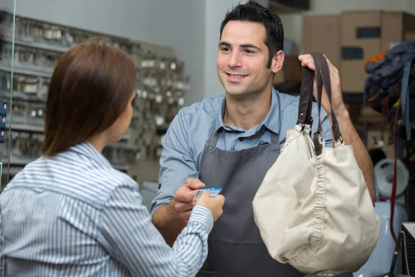 Klant Geeft Haar Kaart Betalen Voor Tas Reparatie — Stockfoto