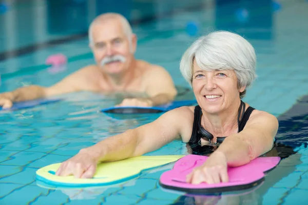 active senior doing aqua gym in outdoor swimming pool