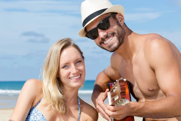 Man Speelt Gitaar Het Strand Naast Vriendin — Stockfoto