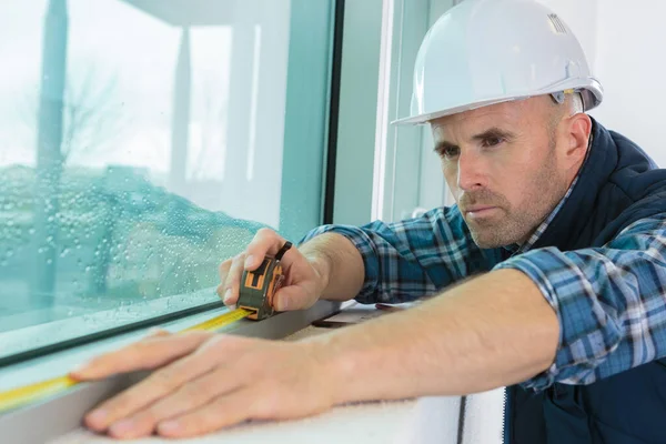 窓の長さを測定する労働者 — ストック写真