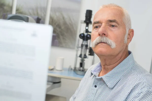 Homem Sênior Leitura Texto Durante Teste Ocular — Fotografia de Stock