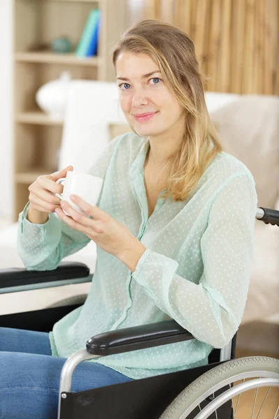 車椅子の幸せな女性がお茶を飲み — ストック写真