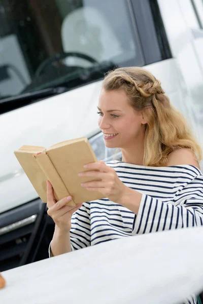 Ελκυστική Νεαρή Γυναίκα Διαβάζει Ένα Βιβλίο Δίπλα Στο Mini Van — Φωτογραφία Αρχείου