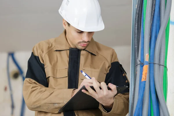 Jonge Mannelijke Aannemer Maakt Notities Klembord — Stockfoto