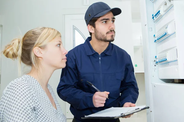 Frau Schaut Männlichen Techniker Der Sicherungsbrett Überprüft — Stockfoto