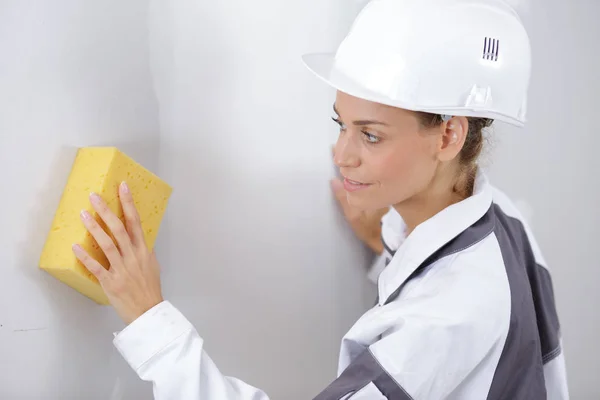 Young Woman Builder Cleaning Wall — Stock Photo, Image