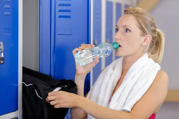 Kvinna Dricksvatten Omklädningsrummet — Stockfoto