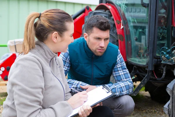 Kobieta Mechanik Schowkiem Patrząc Ciągnik — Zdjęcie stockowe