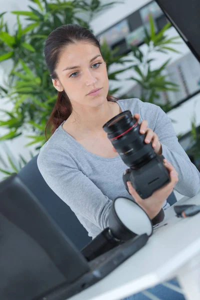 女性写真家チェックカメラレンズ — ストック写真