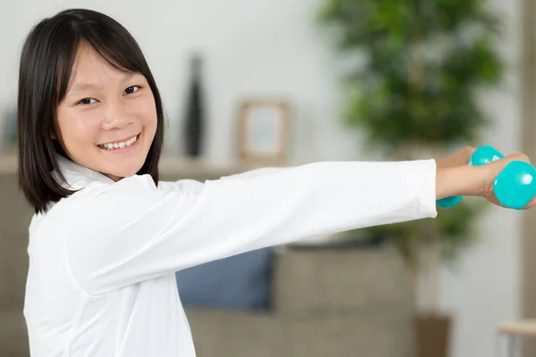 Glückliches Mädchen Das Drinnen Mit Hanteln Trainiert — Stockfoto