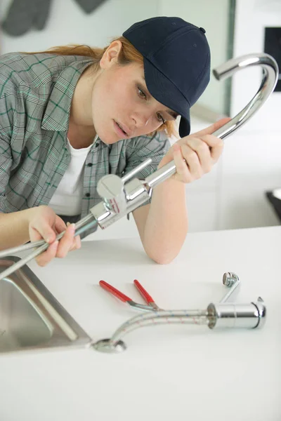 解决水槽问题的年轻女人 — 图库照片