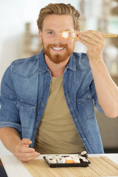 Jovem Homem Segurando Sushi Rolar Seu Olho — Fotografia de Stock