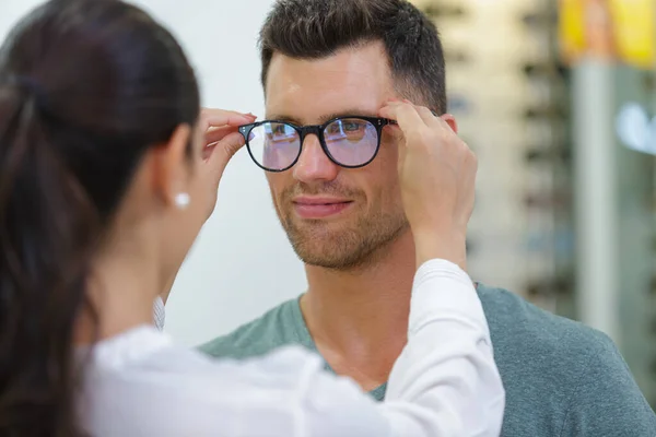 光学系の店でメガネを選択するハンサムな男 — ストック写真