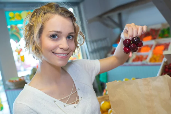 在每周的市场上买水果的年轻妇女 — 图库照片
