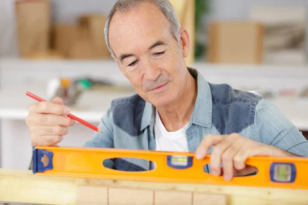 Trabajador Senior Utiliza Nivel Construcción Para Comprobar Equilibrio —  Fotos de Stock