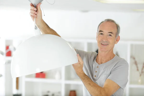 Senior Man Installera Lampa Hemma — Stockfoto