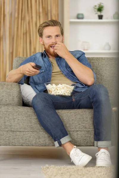 Man Zit Bank Kijkt Met Popcorn — Stockfoto